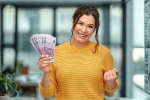 donna che sorride con in mano tante banconote da 500 euro